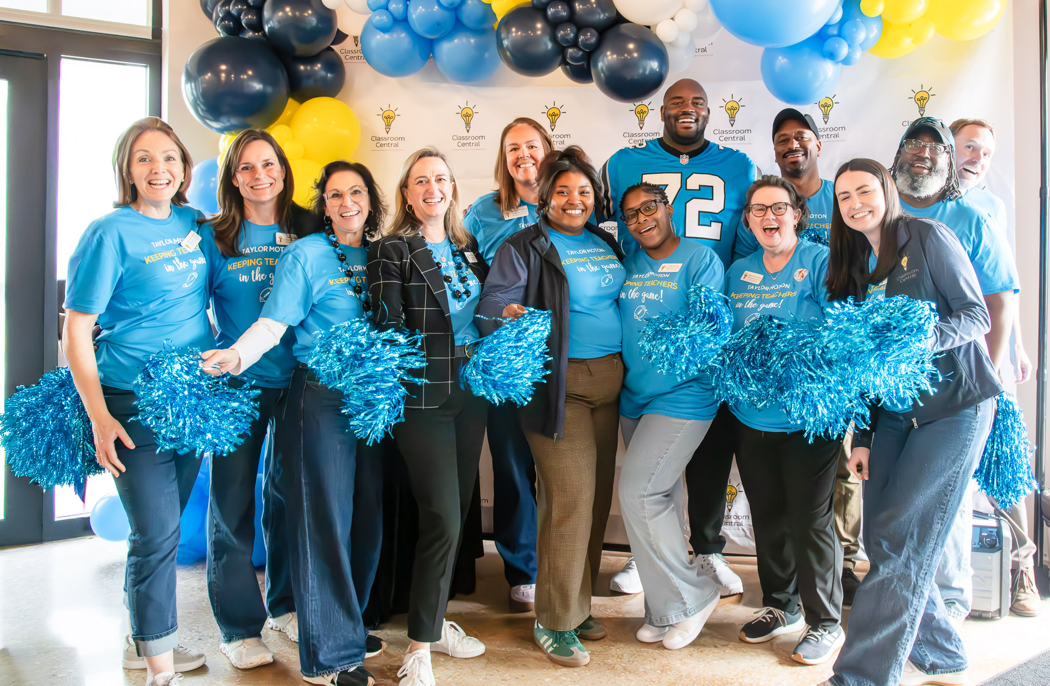 Taylor Moton posing with Classroom Central supporters holding Keeping Teachers shirts